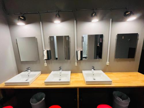 two sinks in a public bathroom with mirrors at Mikami Asakusabashi Hotel in Tokyo