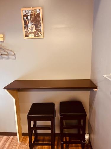 a table with two stools under a wall at Mikami Asakusabashi Hotel in Tokyo