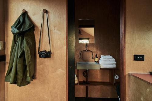 Baño con puerta con lavabo y espejo en Pet Friendly Cabin Surrounded by Wilderness - Gili, en Coleyville