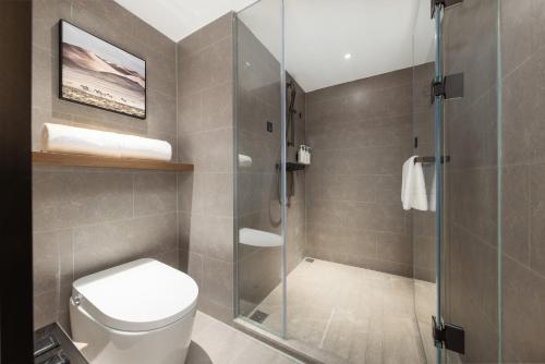 a bathroom with a toilet and a glass shower at Atour Hotel Guangzhou Railway Station University of Chinese Medicine - Complimentary Self-Service Laundry in Guangzhou