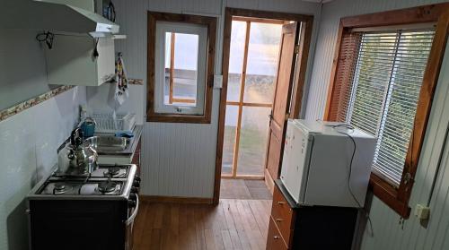a small kitchen with a stove and a refrigerator at Zenteno Osorno Apartment in Osorno