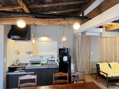 a kitchen with a sink and a table and some lights at 城下町小諸の古民家 - 町屋の隠れ宿-椛庵 Japanese old folk house - momijian in Komoro