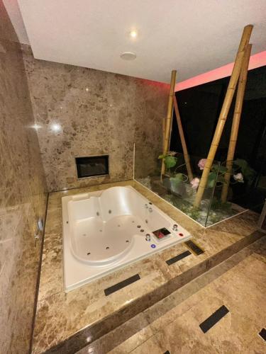 a bath tub in a bathroom with a window at Merry Day Motel Zhonghe Branch in Zhonghe