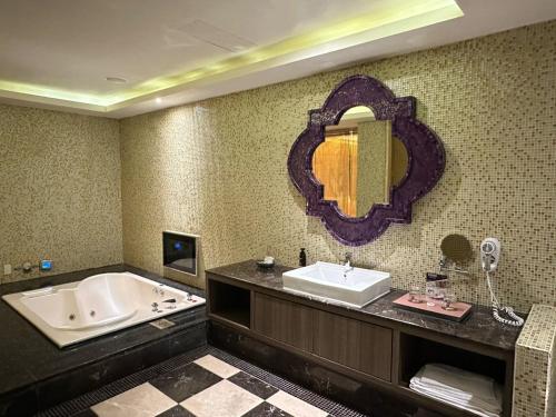 a bathroom with a tub and a sink and a mirror at Merry Day Motel Zhonghe Branch in Zhonghe