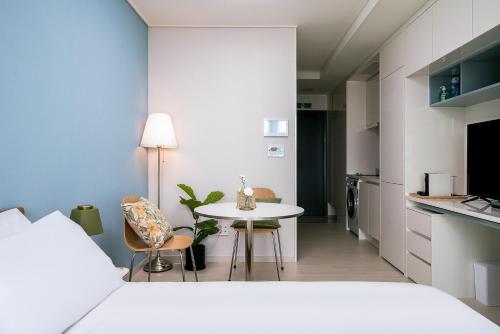 a room with a small table and a kitchen at Urbanstay Songdo Moonlight Park in Incheon