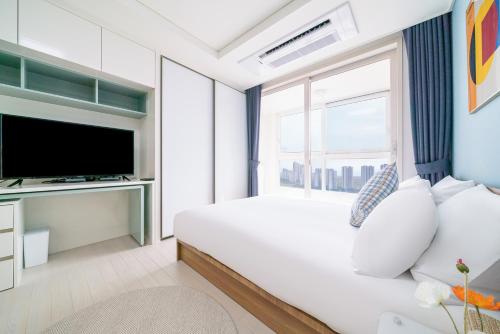 a bedroom with a bed and a large window at Urbanstay Songdo Moonlight Park in Incheon
