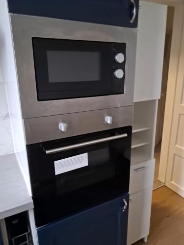 Un four micro-ondes est installé au-dessus d'un four. dans l'établissement 4 pieces disponible, à Nanterre