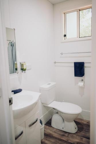 a white bathroom with a toilet and a sink at West View Caravanpark in Dubbo