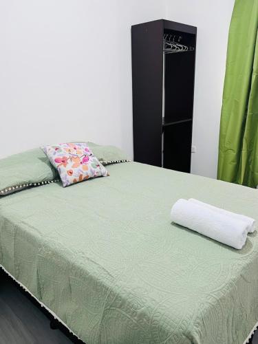 a bed with a green comforter and a pillow at San Francisco Luxury Prestige 2 in Juticalpa
