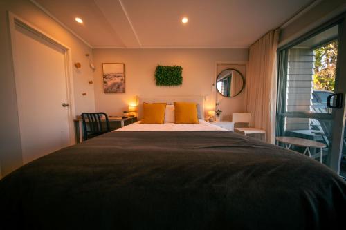 a bedroom with a large bed with yellow pillows at Peace and quiet on the beautiful North Shore in Auckland