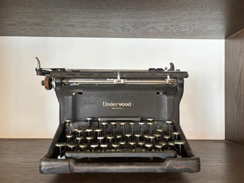 an old typewriter sitting on top of a table at Just Sleep - Taipei NTU in Taipei