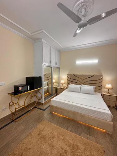 a bedroom with a bed and a ceiling fan at Golden Horizon Suite in Lahore