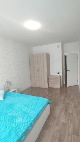 a bedroom with a blue bed and a wooden floor at Polin Kena koht in Raadi