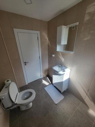a bathroom with a toilet and a sink at Уютен Апартамент in Sofia
