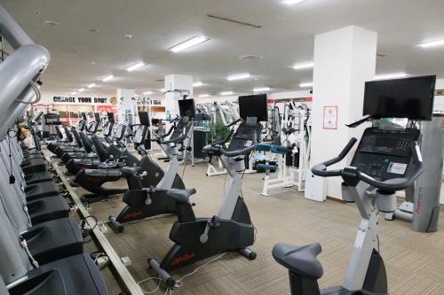 a gym with a lot of treadmills and exercise bikes at Beppu SUGINOI HOTEL in Beppu