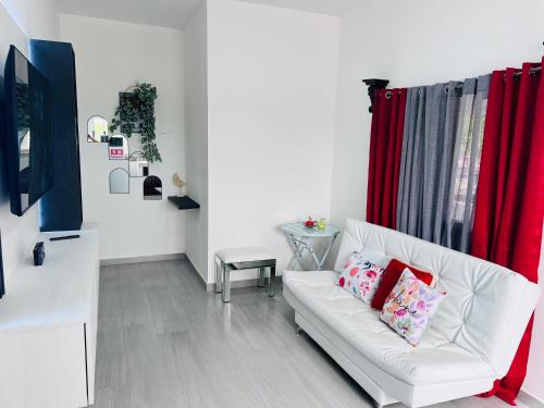 a living room with a white couch and red curtains at San Francisco Luxury Prestige 2 in Juticalpa