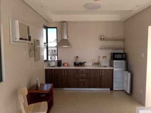 a kitchen with brown cabinets and a white refrigerator at Cristina's Holiday Home in Tagaytay