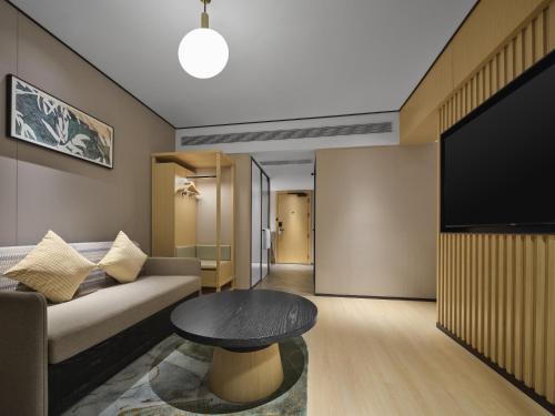 a living room with a couch and a table at Hilton Garden Inn Chengdu Tianfu Panda Tower in Chengdu