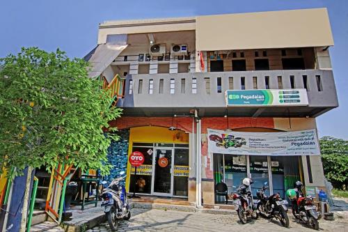 a group of motorcycles parked in front of a building at Hotel O Poris Residence Syariah in Porisgaga