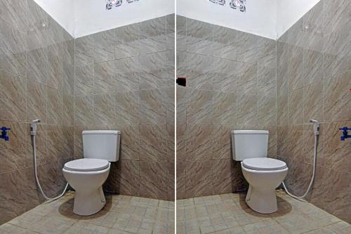 a bathroom with two toilets in a stall at Hotel O Poris Residence Syariah in Porisgaga