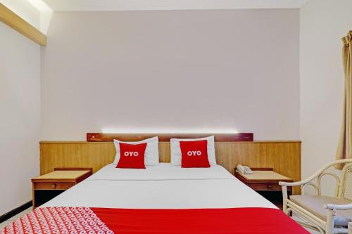 a bedroom with a bed with two red pillows at Collection O Riau Near Trans Studio Bandung Formerly Asteria Hotel in Bandung