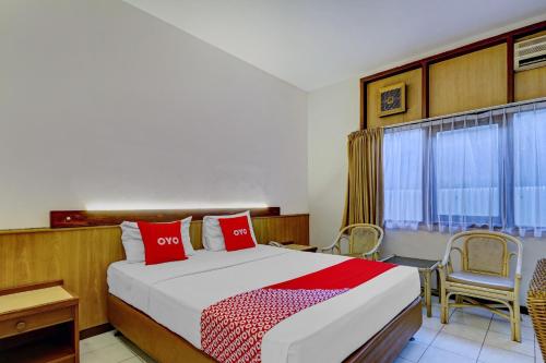 a bedroom with a bed and a table and chairs at Collection O Riau Near Trans Studio Bandung Formerly Asteria Hotel in Bandung