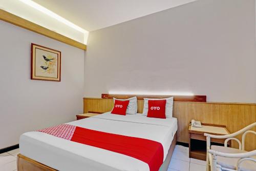 a bedroom with a large bed with red pillows at Collection O Riau Near Trans Studio Bandung Formerly Asteria Hotel in Bandung