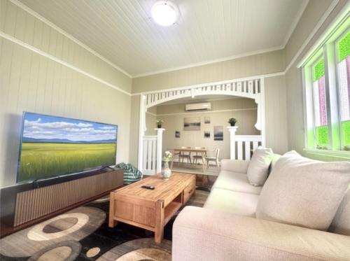 a living room with a couch and a tv at Stylish & Bright 3-BDRS Family in Holland Park West in Brisbane