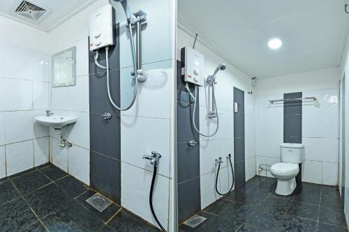 a bathroom with a shower and a toilet and a sink at Hotel O Gemilang in Kuala Terengganu