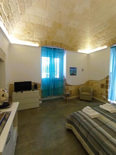 a room with a bed and a tv and a kitchen at Vien dal Mare in Bari
