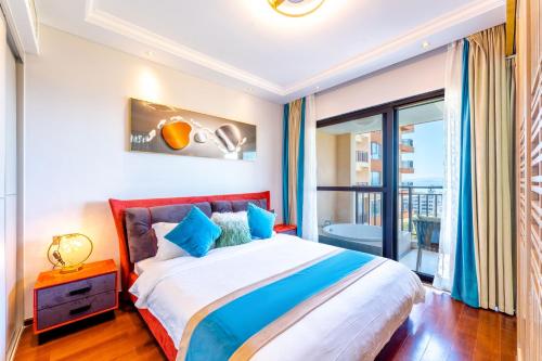 a bedroom with a large bed and a balcony at 福湾海涛 in Sanya