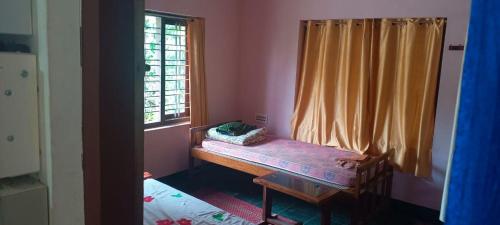 a room with a bench in front of a window at East West Farm Homestay in Munnar