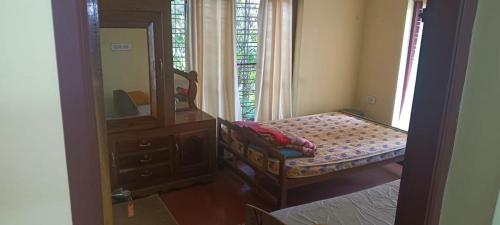 a bedroom with a mirror and a bench in a room at East West Farm Homestay in Munnar