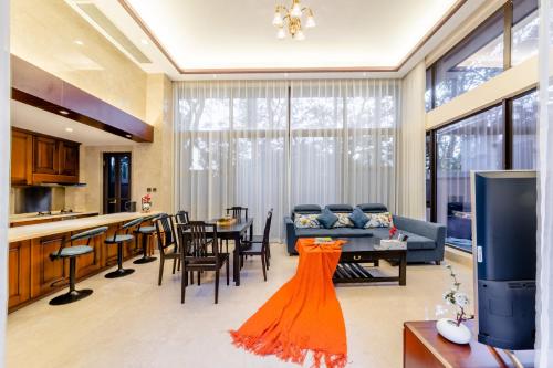 a living room with a couch and a table with chairs at 福湾海涛 in Sanya