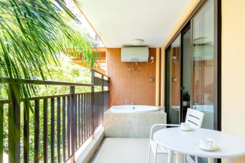 a balcony with a table and chairs and a tub at 福湾海涛 in Sanya