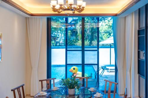 a dining room with a table and a large window at 福湾海涛 in Sanya