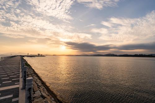 a view of a body of water with the sun setting at 福湾海涛 in Sanya