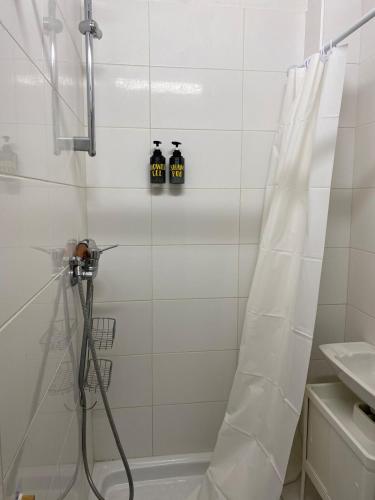 La salle de bains est pourvue d'une douche avec 2 bouteilles. dans l'établissement Loge, Studio facing Gare du Nord, à Paris