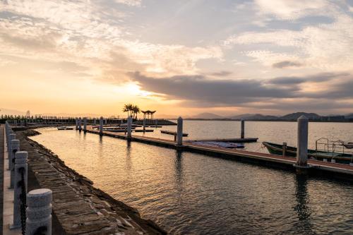 a dock on a body of water with palm trees at 福湾海涛 in Sanya