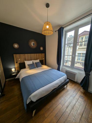une chambre avec un grand lit et une grande fenêtre dans l'établissement Appartement au cœur du centre ville de Blois, à Blois