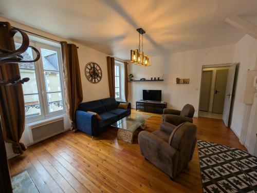 un salon avec un canapé, des chaises et une télévision dans l'établissement Appartement au cœur du centre ville de Blois, à Blois