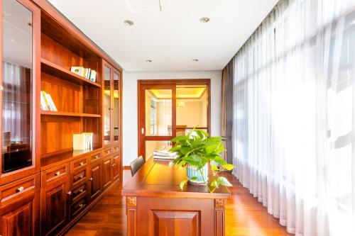 a hallway with wooden cabinets and a plant on a table at 福湾海涛 in Sanya