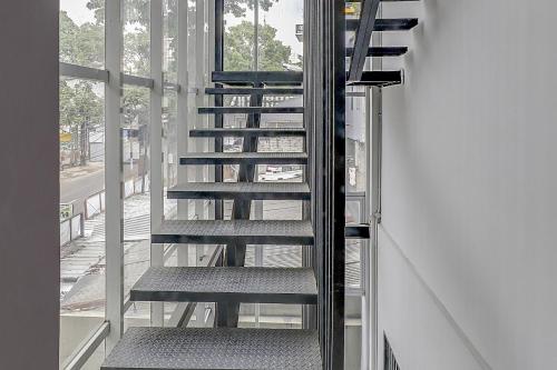 a spiral staircase in a room with a window at Collection O Cihampelas Near Ciwalk Formerly Regia Cihampelas in Bandung