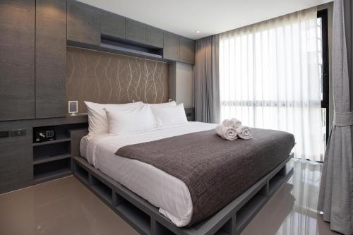 a bedroom with a large bed with a large window at Tropics Kamala 2BR Apartment CTG L702-3, Four Pools, Close beach & Phuket Fantasea in Kamala Beach