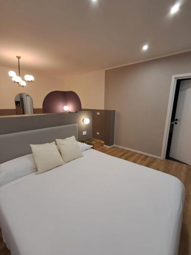 a bedroom with a large white bed with two pillows at - NumberZ - Rooms Apartments and Suites with Wi-Fi and AC in Borgo Isonzo