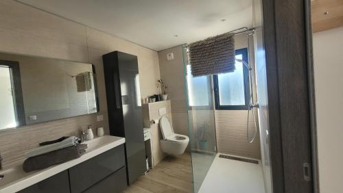 une salle de bain avec toilettes et douche en verre dans l'établissement L'essence du sud avec 4 suites, piscines et four à pizza, à Opio