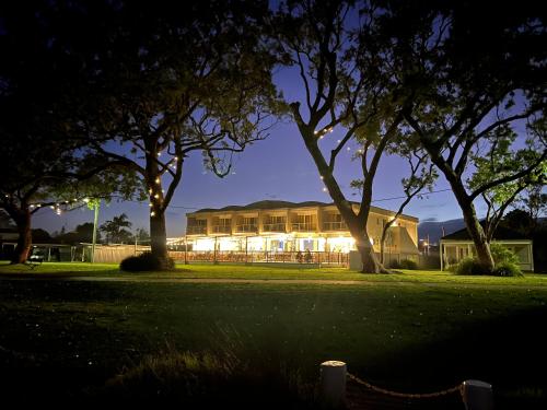 a building lit up at night with trees in front at Sussex Gem - Cozy apartment in the heart of Sussex in Sussex inlet
