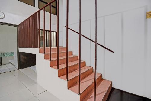a staircase in a house with wooden railings at OYO Life 90791 Royale Margorejo in Wonocolo