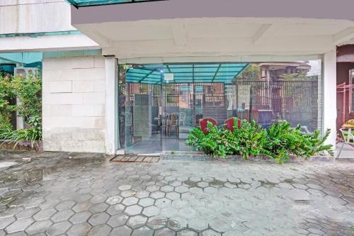 a glass door of a building with plants in front at OYO Life 90791 Royale Margorejo in Wonocolo