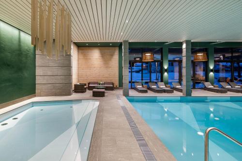 a swimming pool in a hotel lobby with a swimming pool at Hotel Sport Klosters in Klosters